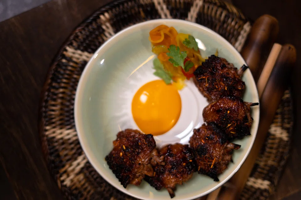 Chicken wings are seasoned and grilled, served with aioli infused with annatto seeds.
