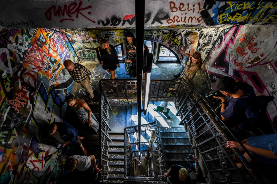 Visitors walk down a stairwell decorated with graffiti during a press preview at the Fotografiska photography museum, housed in the former art squat "Tacheles" in Berlin. 