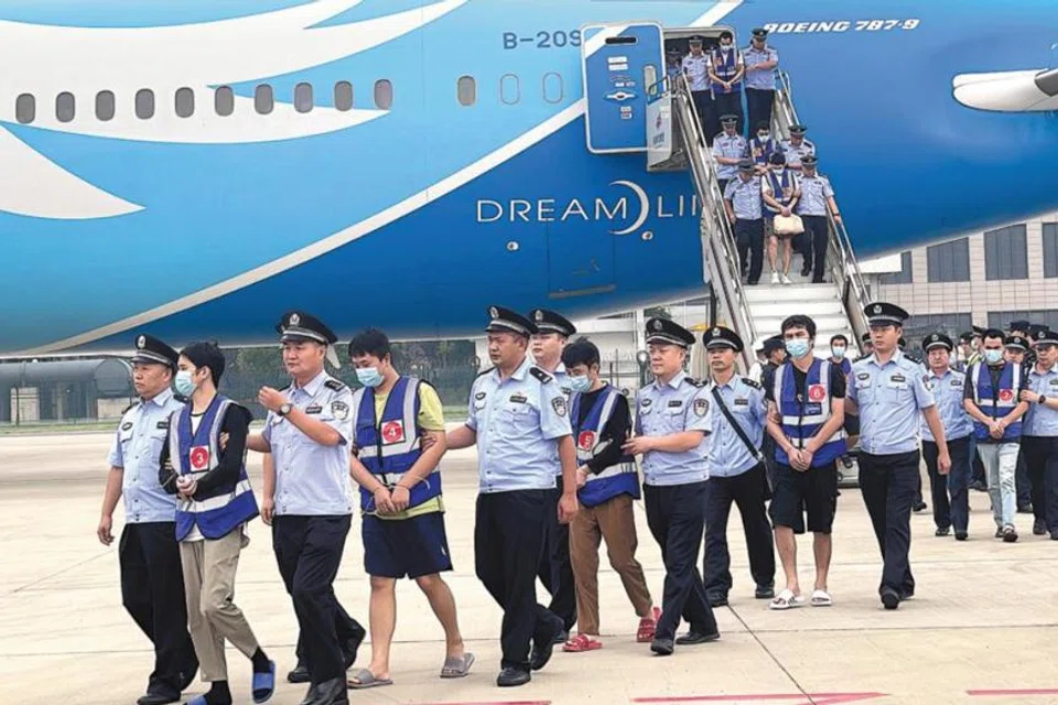 Suspects are escorted by police from a chartered civil aircraft which landed at Zhengzhou Xinzheng International Airport in Henan province on Sep 11. 