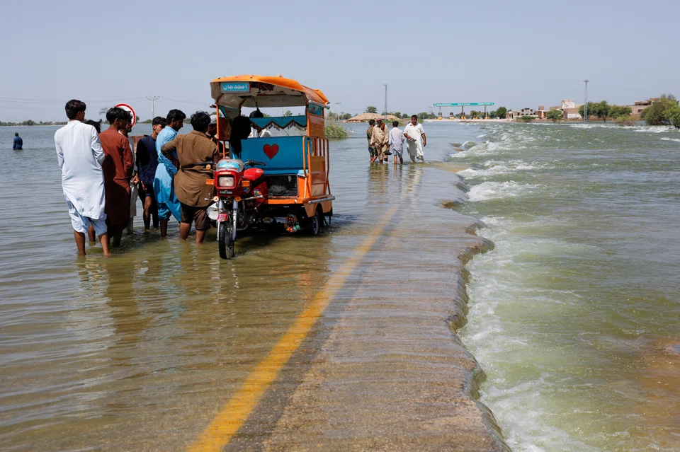 Displaced people on a flooded highway following rains and floods during the monsoon season in Sehwan, Pakistan, in September. 