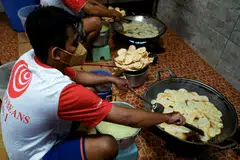 Employees fry sliced tempe, a traditional Indonesian food made from fermented soybeans, at a home industry that produces chips in Jakarta May 18, 2022. 
