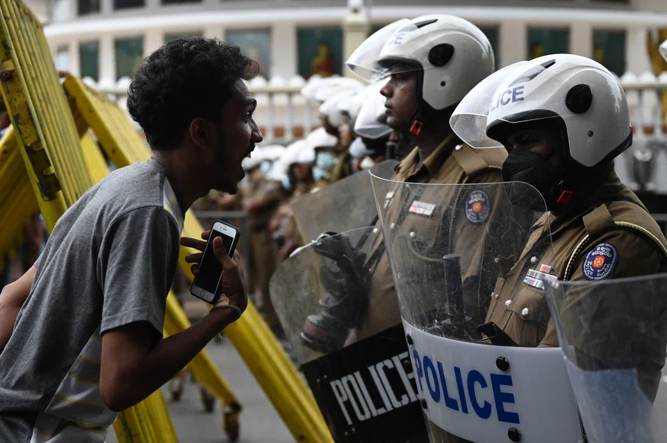A demonstrators arguing with Police special task force officers at a road block during a protest march against Sri Lankan President Ranil Wickremesinghe in July. He fled the country shortly thereafter.  