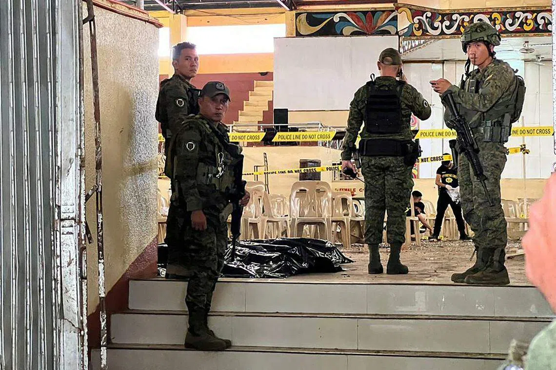 Military personnel stand guard at the entrance of a gymnasium while police investigators look for evidence after a bomb attack at Mindanao State University in Marawi, Lanao del sur province, Philippines, Dec 3, 2023. 