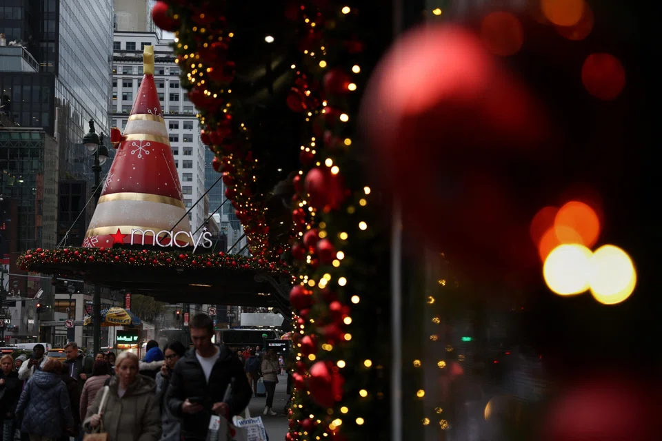 People walk by a Macy's department store in New York City, US, Dec 4, 2023. 