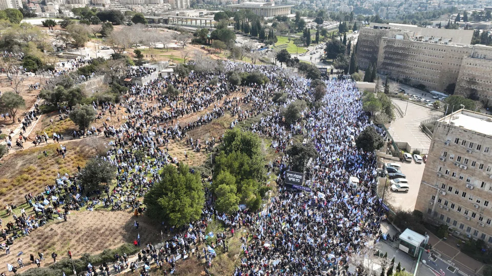 Israelis demonstrating in front of parliament on the day Israel's constitution committee is set to start voting on changes that would give politicians more power on selecting judges while limiting Supreme Court powers to strike down legislation.