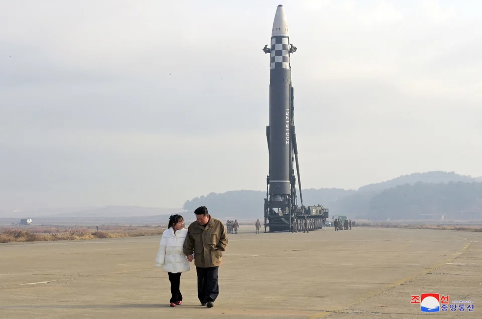 North Korean leader Kim Jong Un, along with his daughter, walks away from an intercontinental ballistic missile (ICBM) in this undated photo released on Nov 19, 2022 by North Korea's Korean Central News Agency.