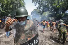 Security forces fire tear gas to disperse protesters who broke through police barricades and stormed into the Prime Minister's office on 13 July. Sri Lankan authorities declared a state of emergency and imposed a curfew in the Western Province of the country. 