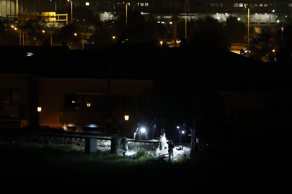 Police members investigate an area where four people were hit by a train and died while trying to cross the train track in an unauthorised place in Montmelo, near Barcelona, Spain, Sept 10, 2023.  