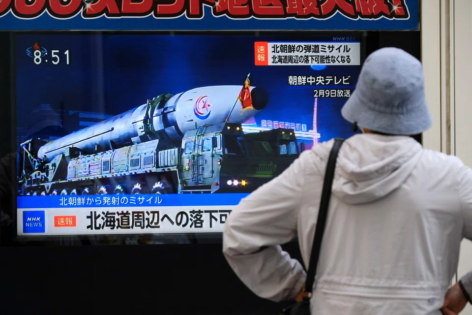A woman watches street TV broadcasting breaking news of a North Korean missile launch in Tokyo on April 13, 2023. 