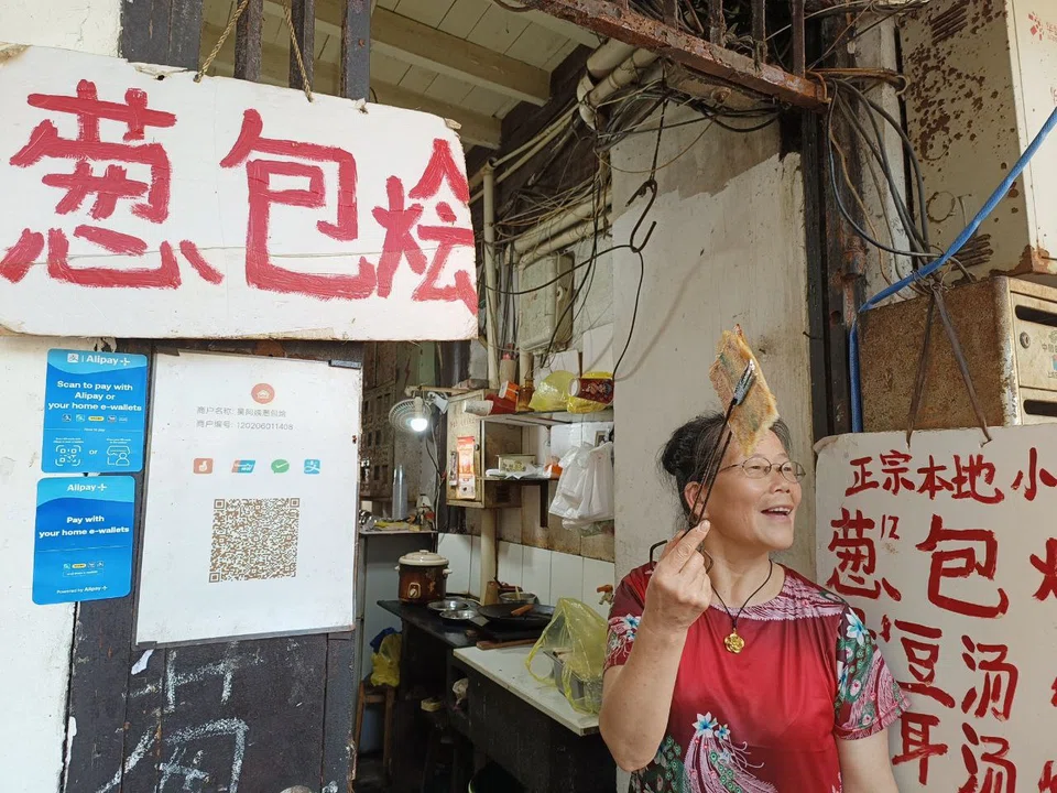 Aunty Wu, a street food vendor in Hangzhou, sports the Alipay+ QR code at her storefront. This allows her to receive payments directly from participating foreign bank apps and e-wallets.