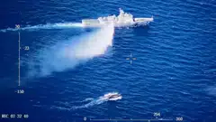 This screen grab from a video released on Tuesday (Aug 8) shows a Chinese Coast Guard ship launching what the Coast Guard says is a warning water cannon spray in the direction of a Philippine vessel at an unknown location at sea.     