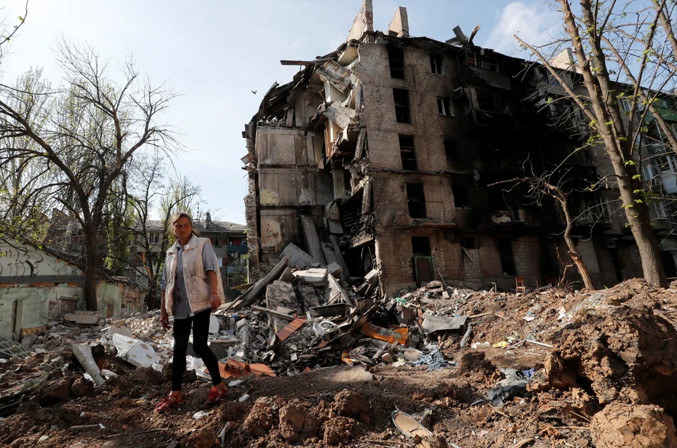 Local resident and social worker Oksana Khvostenko, 47, stands near her house, which was heavily damaged during Ukraine-Russia conflict in the southern port city of Mariupol, Ukraine April 29, 2022. REUTERS/Alexander Ermochenko