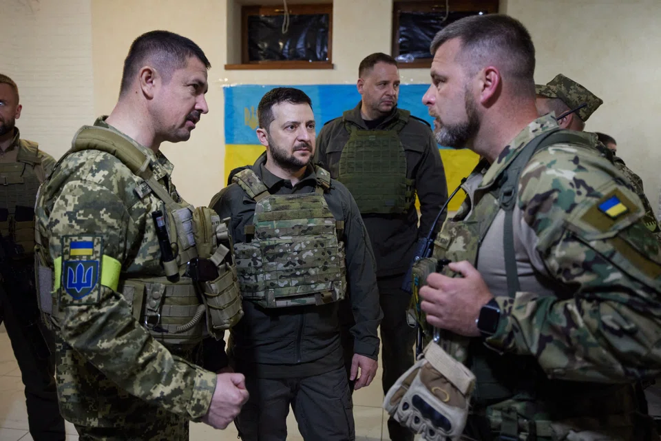Ukrainian President Volodymyr Zelensky (centre) talk with servicemen during his visit to the Kharkiv region. 