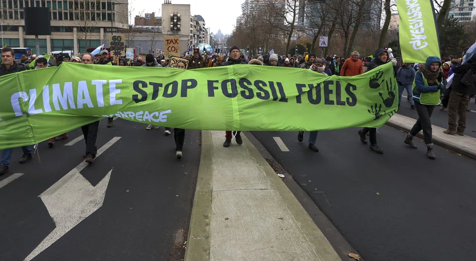 People protest against fossil fuels in Brussels, Belgium, Dec 3, 2023. The protest, coinciding with the COP28 in Dubai, is calling for urgent measures to combat climate change. 