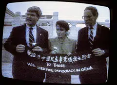 A television image of Nancy Pelosi, center, holding a banner with other congressional members in Beijing in Sep 1991.