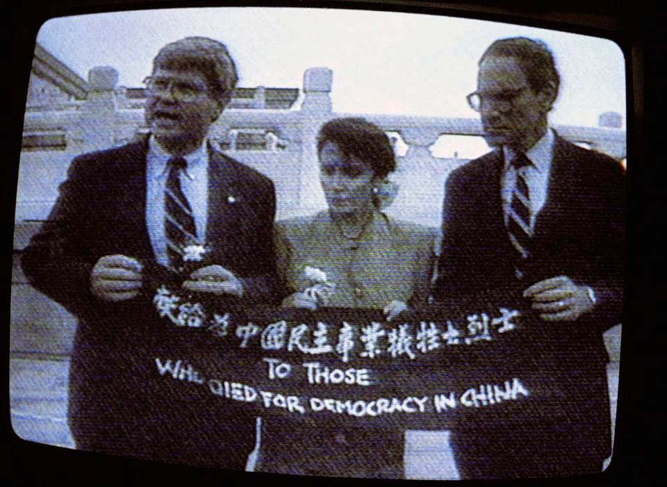 A television image of Nancy Pelosi, center, holding a banner with other congressional members in Beijing in Sep 1991.