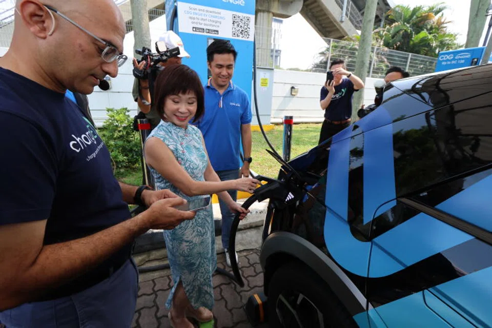 Senior Minister of State Amy Khor trying out an EV charging app at the launch of the largest e-roaming service across both sides of the Causeway in October. 
