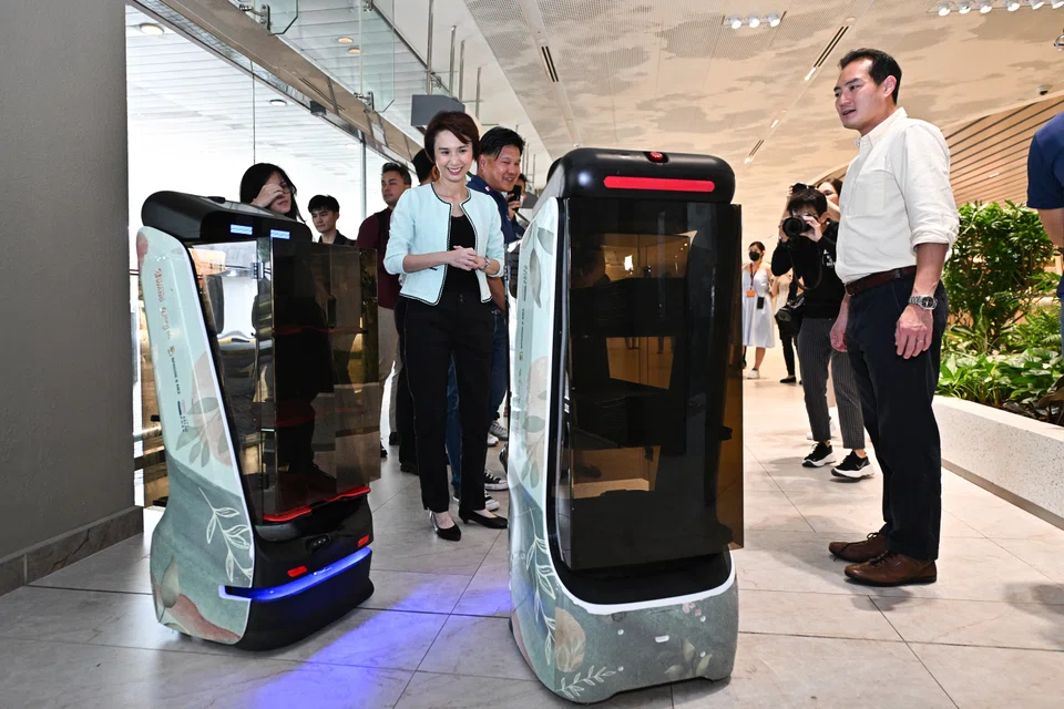 Minister of State for Trade and Industry Low Yen Ling and Senior Minister of State for Communications and Information Tan Kiat How at the launch of the refreshed Food Services IDP at Heavenly Wang with its service robots.