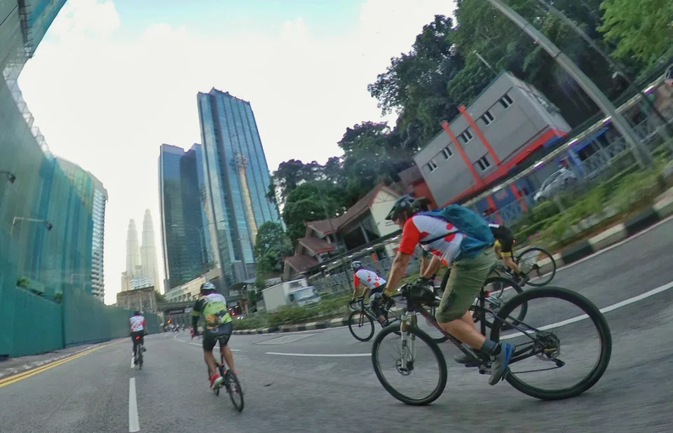 Cyclists at the OCBC Cycle Kuala Lumpur event making their way towards the Petronas Towers.