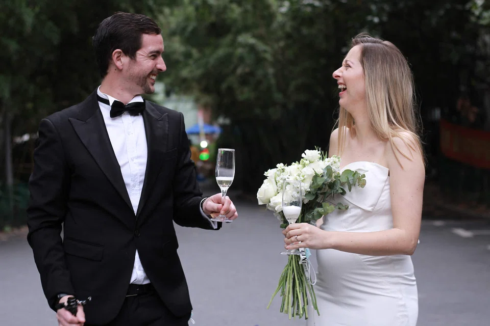 Groom Matthew Mitchener with his bride Janelle Nuyts celebrating their wedding in the car park of their housing compound in Shanghai after a ceremony officiated via Zoom from the US. 