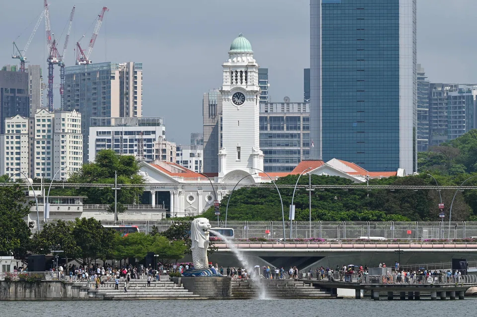 People gather around the Merlion statue at Marina Bay in Singapore; Singaporeans tend to grumble about the hot and humid weather. 