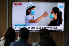 People watch a TV broadcasting a news report on the Covid-19 outbreak in North Korea, in Seoul, South Korea, May 17, 2022. Kim Jong Un on Thursday declared victory in the battle against Covid-19, ordering a lifting of maximum anti-epidemic measures imposed in May.