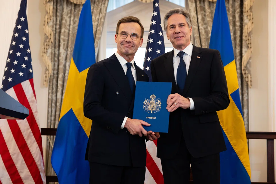 (From left) Sweden's Prime Minister Ulf Kristersson posing with US Secretary of State Antony Blinken after receiving Nato ratification documents during a ceremony to formalise Sweden's membership in Nato at the Department of State in Washington, DC, March 7, 2024.  