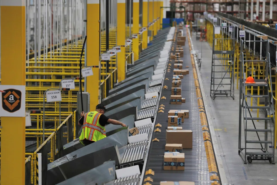 Amazon packages being pushed on to ramps leading to delivery trucks by a robotic system; unlike traditional storage sites, fulfilling online orders requires technologically advanced warehouses, saidys Mark Manduca, chief investment officer at GXO.