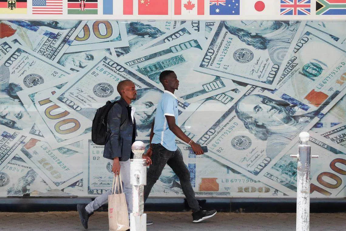 People walk past a currency exchange bureau in downtown Nairobi, Kenya. Africa’s rapidly depreciating currencies are eroding households’ savings.
