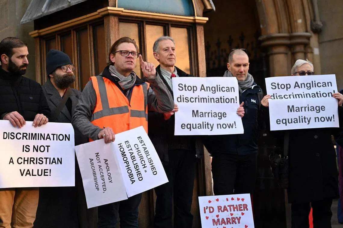 Pro-LGBT+ activists take part in a demonstration outside of Church House, in London, on day three of the Church of England's General Synod. A priest asked about developing more inclusive language for those who wish to speak of God in a “non-gendered way”.
