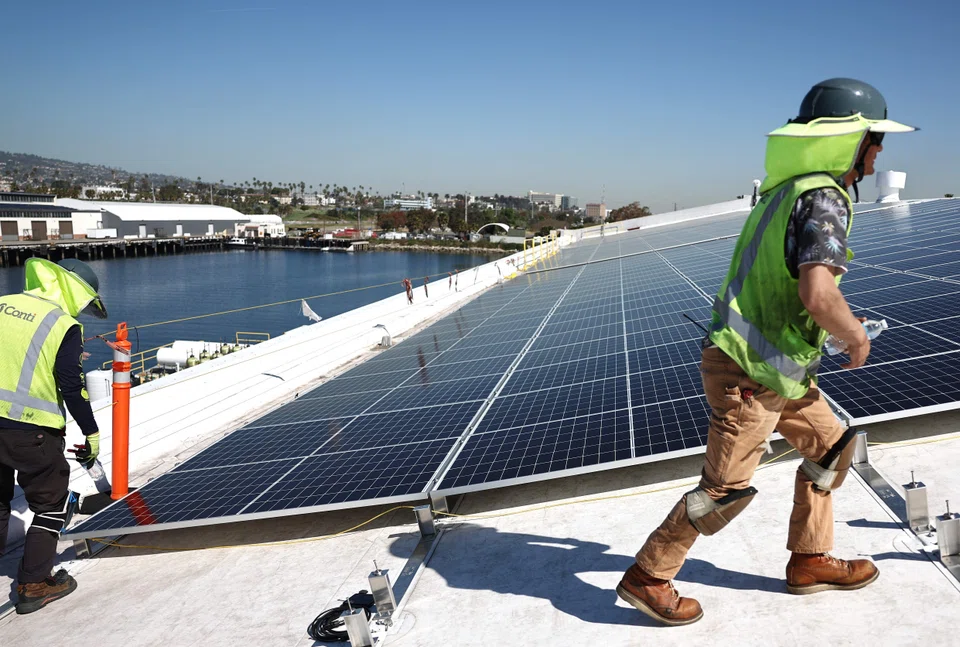 Installation of solar panels atop a roof in Los Angeles, California. A record of more than US$1.7 trillion will be invested in clean-energy technologies this year, compared about US$1 trillion going into fossil fuel supplies and power production. 