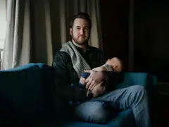 Alex Gable, who was laid off from his job while on paternal leave, with his son, in Washington, Feb. 1, 2023. He had been laid off months after choosing the company for its generous paternity leave policy and openness toward work-life balance.