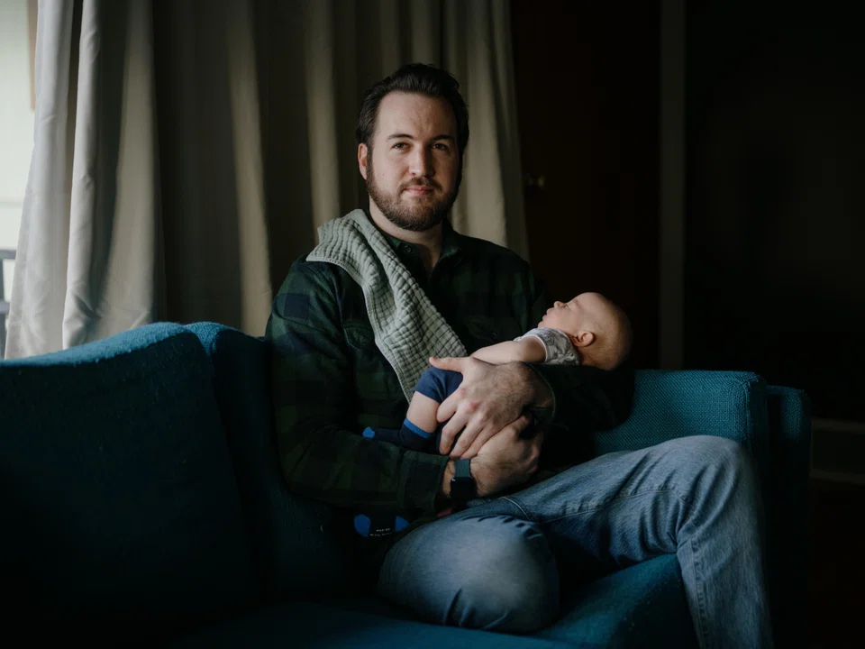 Alex Gable, who was laid off from his job while on paternal leave, with his son, in Washington, Feb. 1, 2023. He had been laid off months after choosing the company for its generous paternity leave policy and openness toward work-life balance.