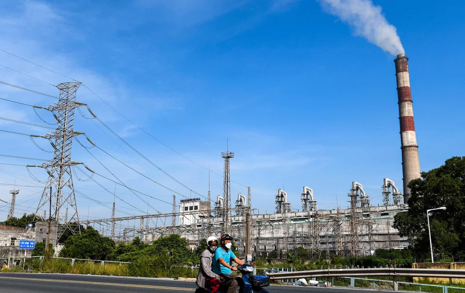 A motorbike passes Pha Lai thermal power plant in Vietnam's Hai Duong province. Even though the country may have the highest amount of installed solar and wind energy capacity in South-east Asia, many of these farms are unable to operate at full capacity.