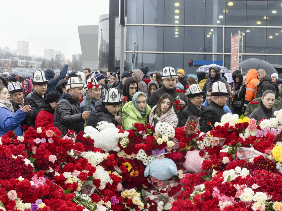 People lay flowers at a makeshift memorial near the Crocus City Hall, a popular concert venue where at least 137 people were killed on Friday night in an attack outside Moscow, March 24, 2024. 