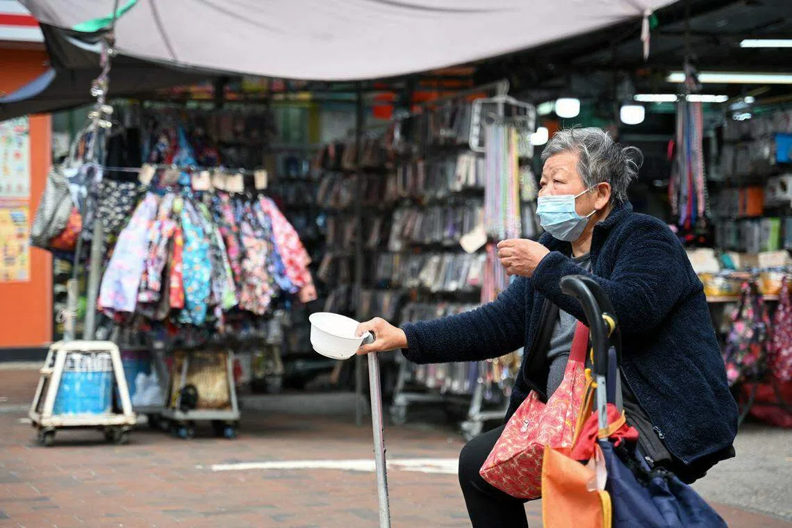 An elderly woman begs for alms in the Kowloon district of Hong Kong. By improving dozens of outcomes simultaneously, cash transfers offer a transformative solution to multidimensional poverty.