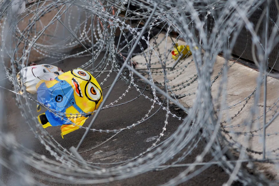 Balloons are caught in barbed wire as activists protest after Indonesia's parliament overhauled the criminal code.