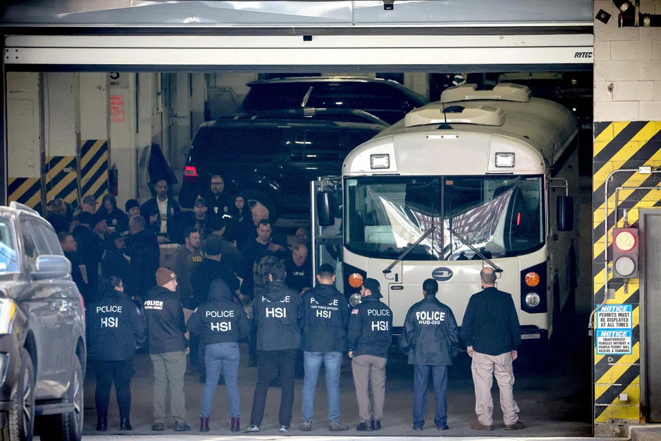 Members of Homeland Security Investigations and New York City Department of Investigation load people arrested on to a bus, after many current and former New York City Housing Authority employees were charged with bribery and extortion offences.
