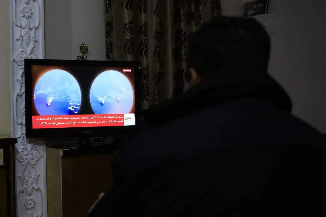 A person watches the news on a Houthi-run TV after a UK-registered ship came under attack in the Red Sea, in Sana'a, Yemen. 