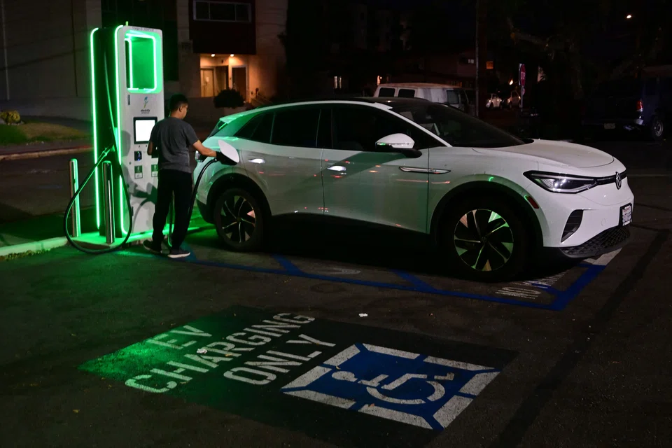 A driver charging his electric vehicle in Monterey Park, California. In Los Angeles, 13.8 per cent of new cars this year run on electricity. New York City lags this - fully electric cars and plug-in hybrids account for 8.9 per cent of new cars in the city this year. 