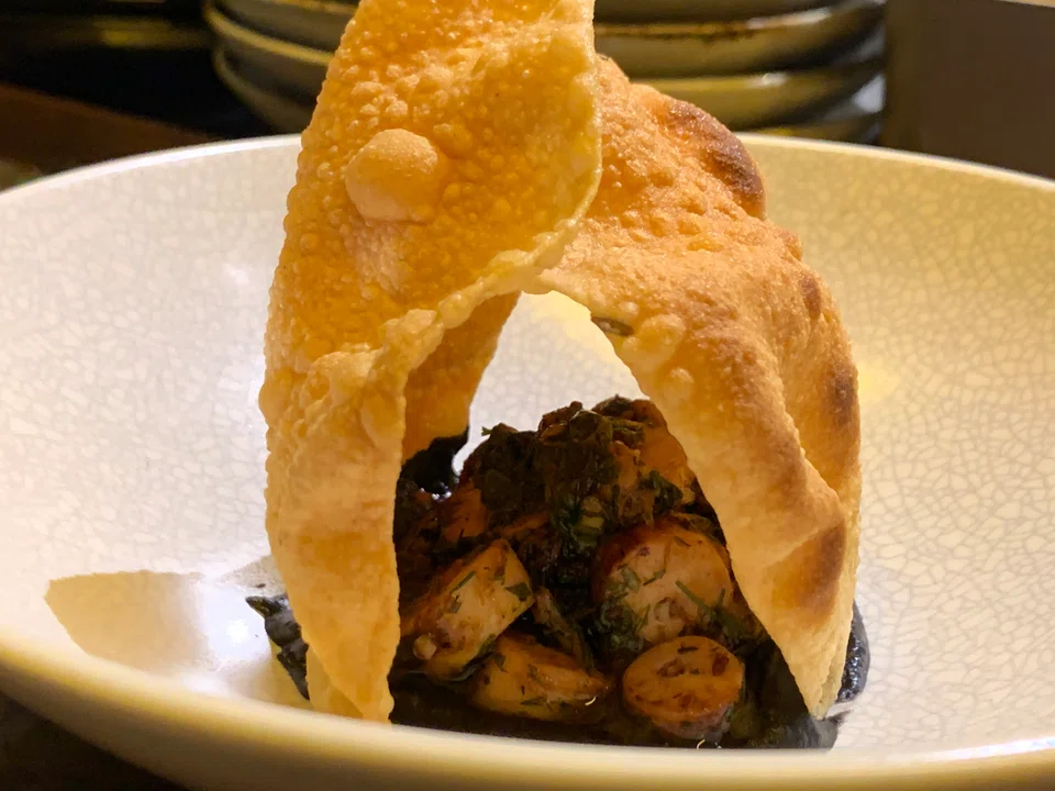 Slow-cooked octopus on white bean purée served with dal crackers.