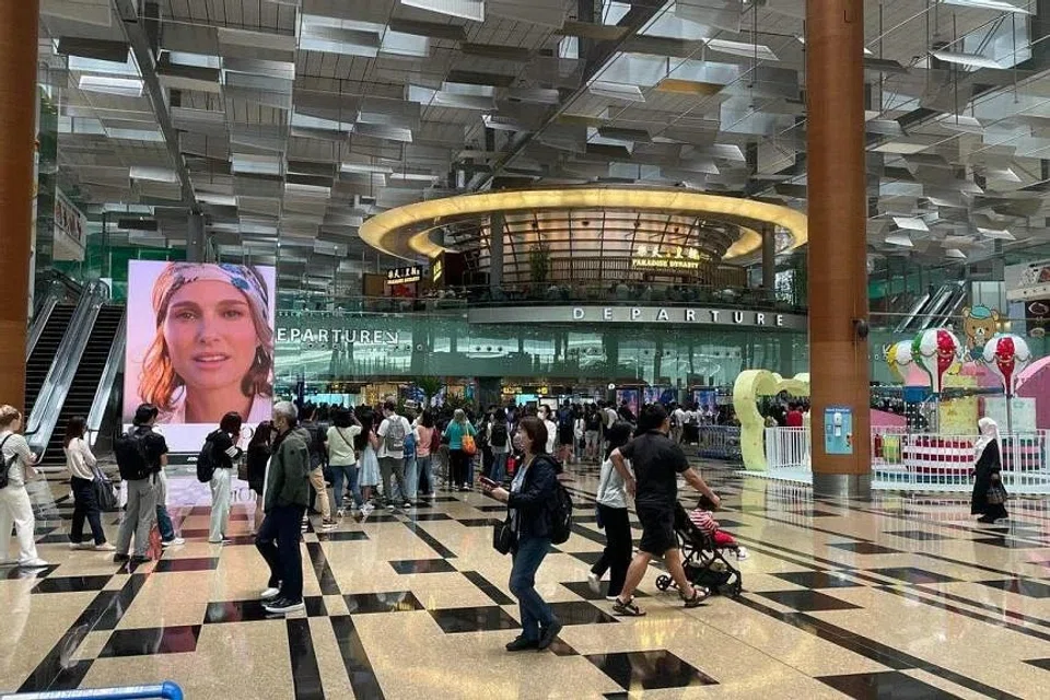 Long queues had formed at Changi Airport, with throngs of people waiting to enter departure gates. 