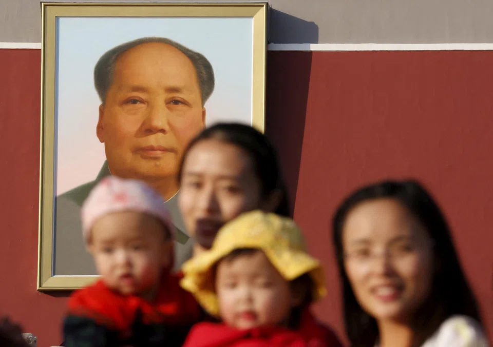 Two women and their babies pose for photographs in front of the giant portrait of late Chinese chairman Mao Zedong on the Tiananmen Gate in Beijing November 2, 2015.