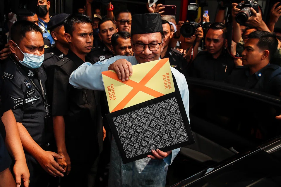 Malaysia's Prime Minister and Finance Minister Anwar Ibrahim holds the 2023 Malaysia's budget document at the Finance Ministry building as he departs to Parliament on Feb 24, 2023. This is the first budget by Anwar's unity government.