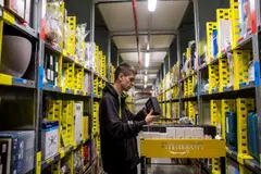 An employee collects customer orders from an aisle in an Amazon.com Inc fulfilment centre in Dobroviz in the Czech Republic. The company now wants to its warehouses to be in urban centres so that orders by online shoppers can be delivered in shorter time - and is taking steps to buy its own space. 