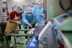 Minister for Manpower and Second Minister for Trade and Industry, Tan See Leng (second from left) viewing automated pau encrusting at Sin Mui Heng Food Industries. 