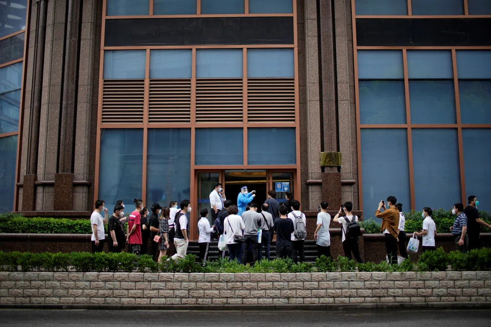 Staff members wait at an entrance to enter a shopping mall after a Covid-19 lockdown was lifted in Shanghai, June 1, 2022. 
