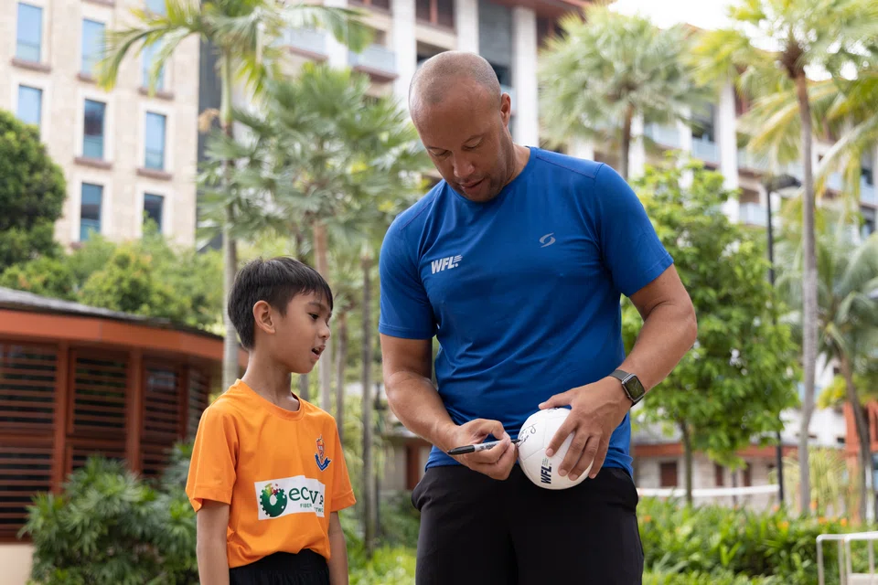 Children walk away with a Christmas gift of autographed mini football from Mikael Silvestre.