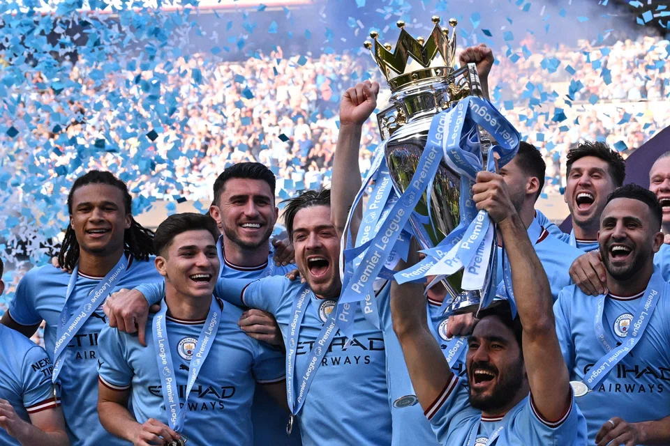 Manchester City's Ilkay Gundogan lifts the trophy as its players celebrate winning the title at the presentation ceremony following the English Premier League football match between Manchester City and Chelsea at the Etihad Stadium in Manchester, England, May 21, 2023. 