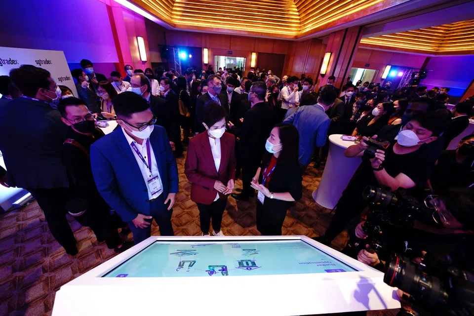 Minister for Communications and Information Josephine Teo (centre) with regional commercial manager of Advario Kelvin Ling (left) and SGTraDex Services head of market development Thaw Yee Leng (right) at the product demonstration for SGTraDex.